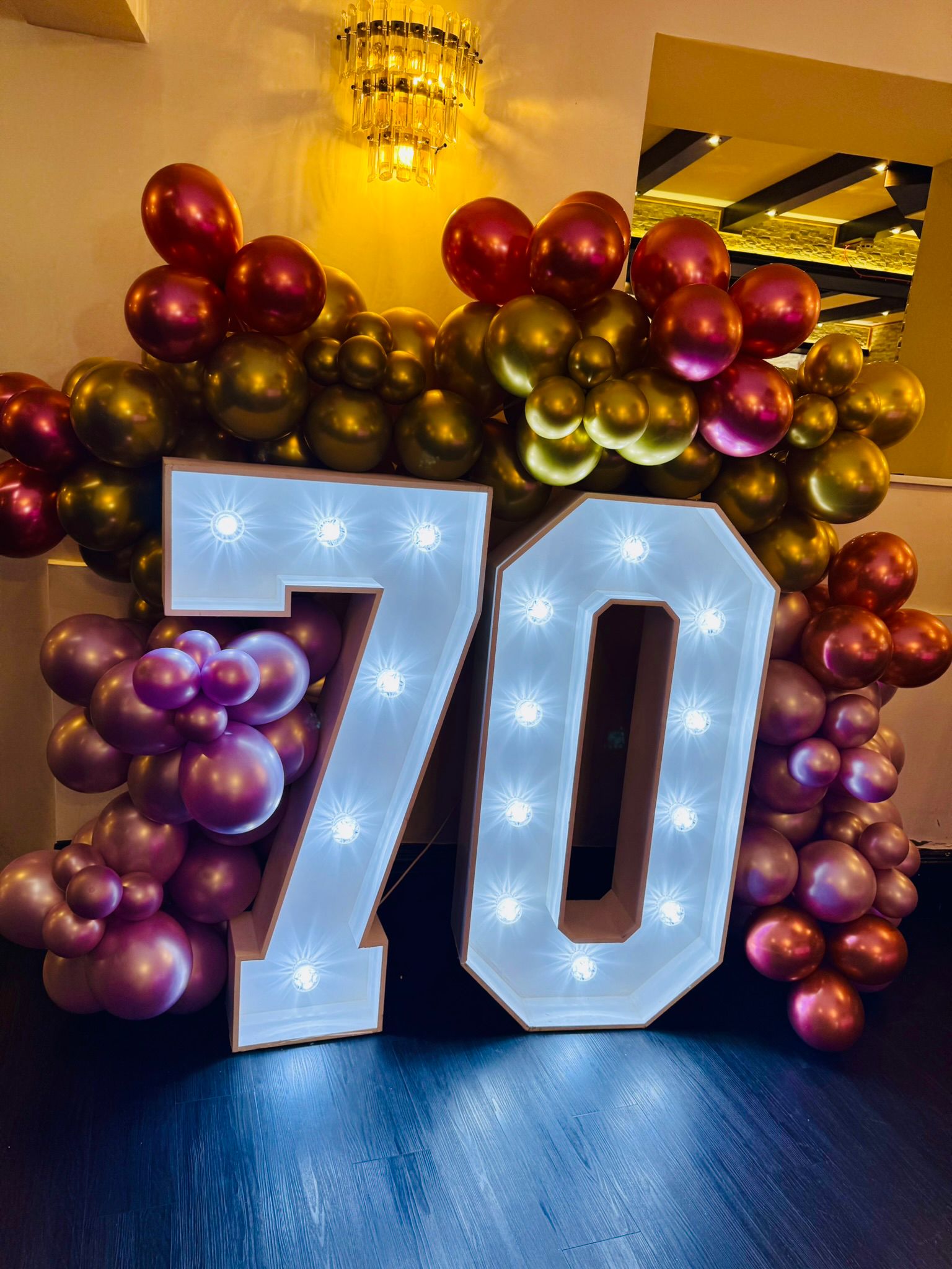 Number 70 display with red metallic balloons