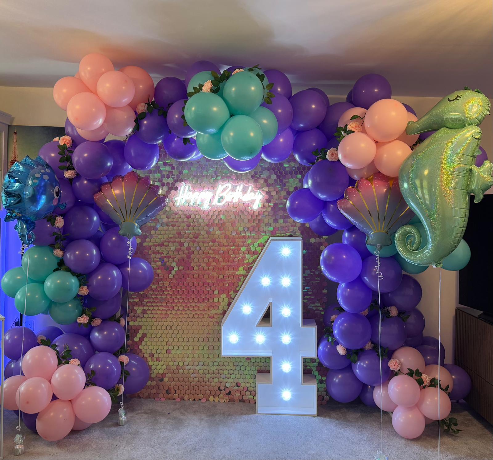 Birthday party backdrop decorated with balloons and signage